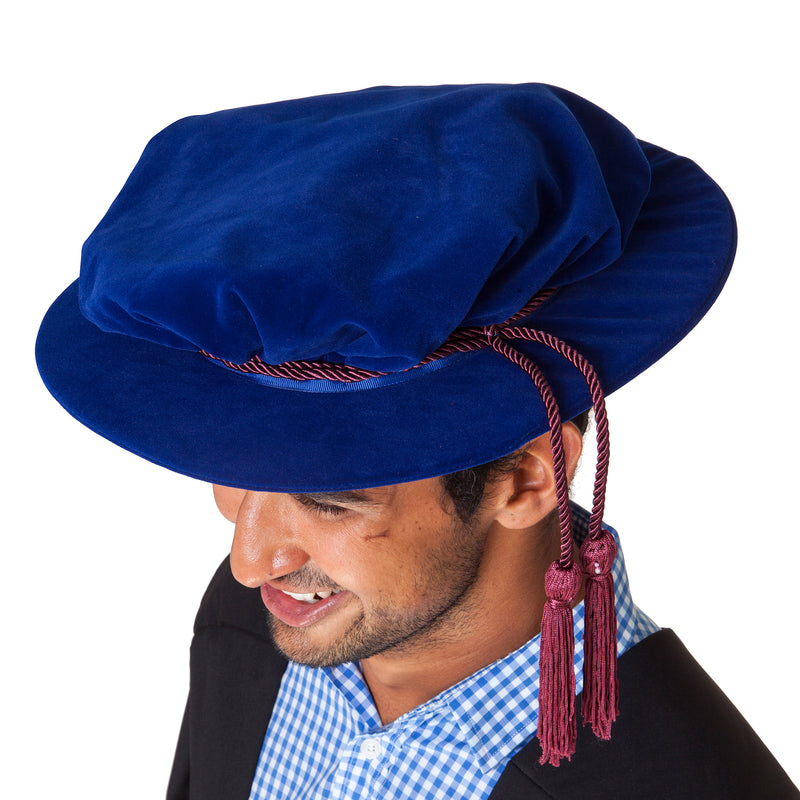 Top view of a blue velvet hat with crimson cord