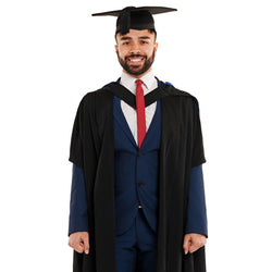 Man wearing a Uni Newcastle graduation set with graduation gown and mortarboard