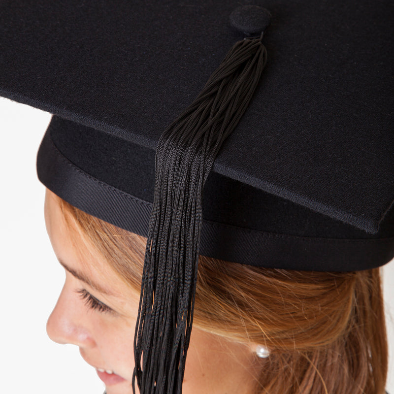 Detailed photo of a black felt mortarboard (graduation cap) with black tassel