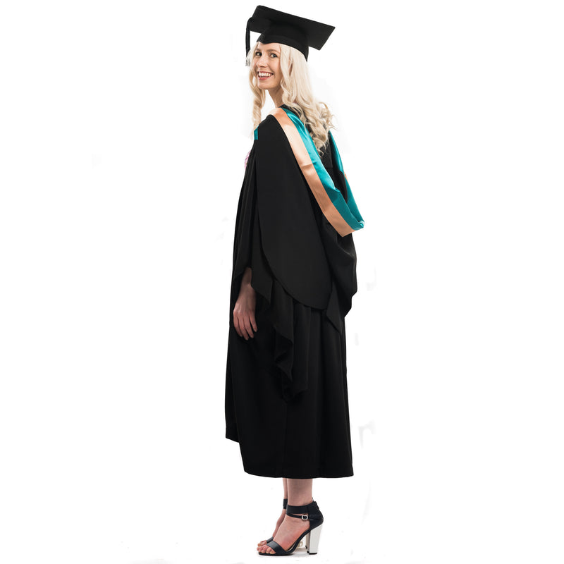 Woman wearing a Uni New England graduation gown and graduation hood with graduation hat